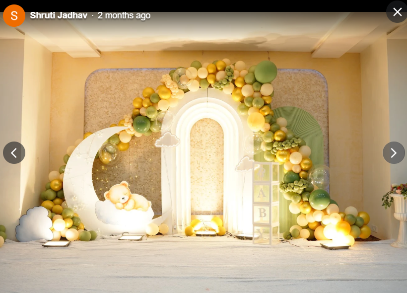 Sage green and gold balloon arch with sleeping bear moon prop
